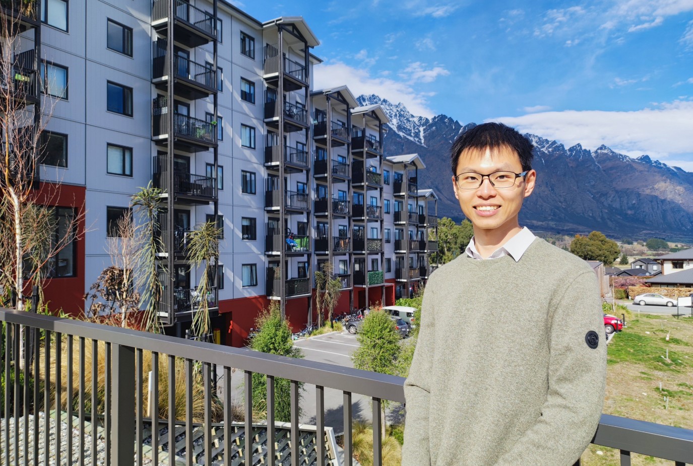 Arthur Lee in front of QLCHTs Toru Apartments built with New Ground Capital