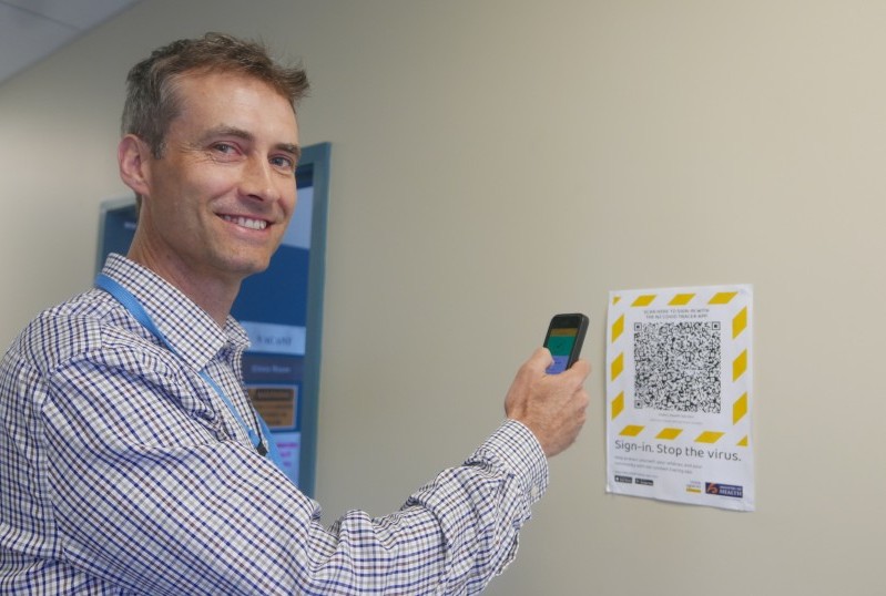 Dr Michael Butchard Medical Officer of Health scanning a QR code 2 1