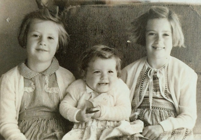 Elaine right with her sisters sitting on bales of wool on the Earnslaw