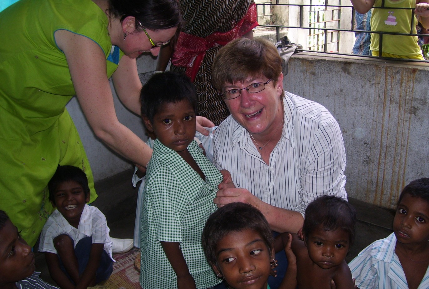 Lynn Baxter right helping dress children during a visit to Nepal and India with Orphans Aid CEO Sue van Schreven in 2007