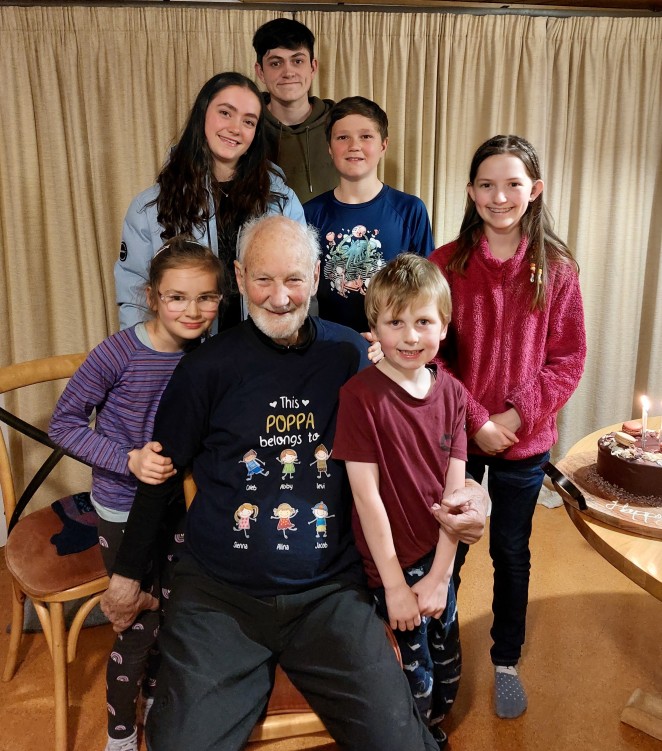 Neill celebrating an early 90th birthdayJ wearing his celebration T shirtJ with his precious grandchildrenJ left to rightJ CalebJ AbbyJ LeviJ frontJ SiennaJ Alina and Jacob